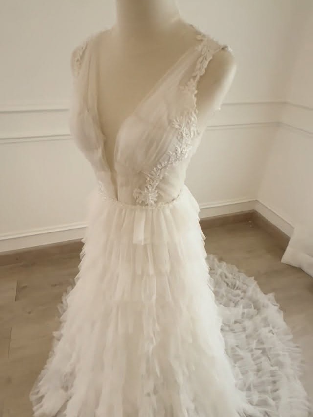 Vestido de novia en tul con volantes y cola
