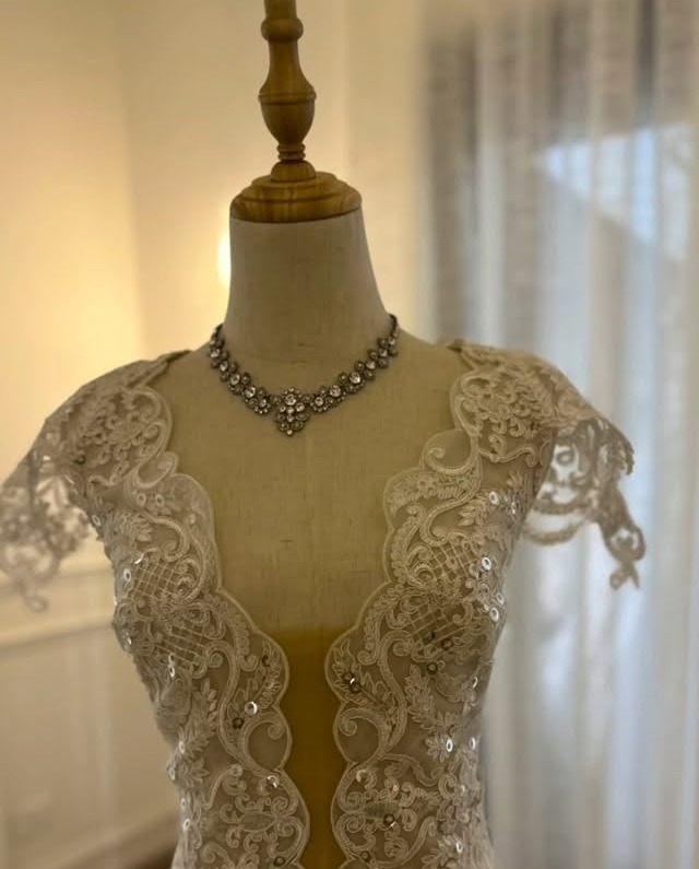 Vestido de novia en encaje con pedrería sobre maniquí